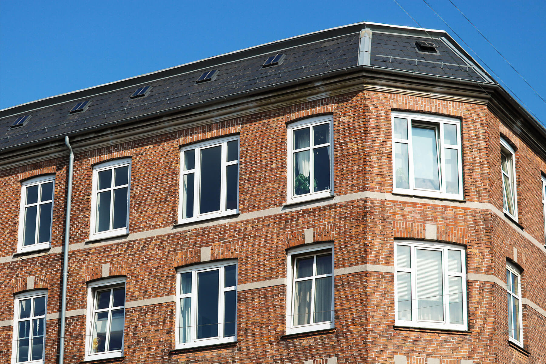 De øverste vinduer og taget på ejendommen tilhørende andelsboligforeningen på Provstevej 12 og Thoravej 18 i København NV
